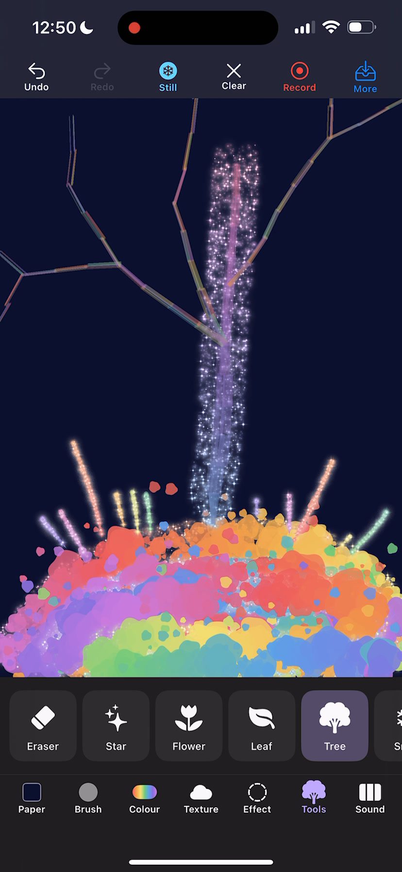 Rivaurie with the stamp tray open, showing star, flower, leaf and tree, above a glittering tree grown over a mound of color